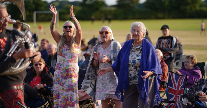 Group of older woman dancing and smiling watching a brass band perform at durham brass festival.